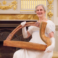 Photo of Talitha McKenzie holding a harp