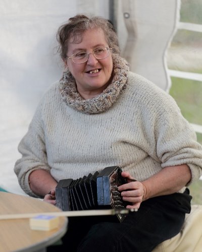 Ann Hinchliffe seated playing accordion