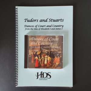 Photo of spiralbound book with CD placed on it on a dark green desk.