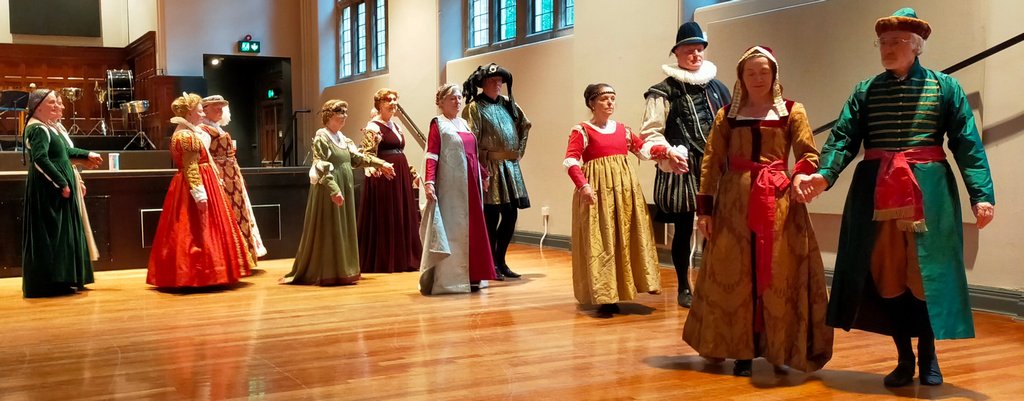 Six couples dancing in Renaissance dress